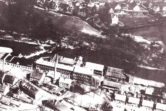 Luftaufnahme von April 1920, Jahr nach Hochwasser 1919 Fabrikgebäude (m), Arbeitersiedlung (ur), Schloss (om)